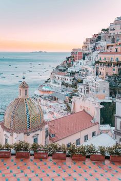 the rooftops and roofs of buildings overlooking the ocean at sunset in positi, italy