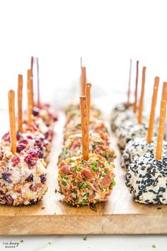 an assortment of appetizers with toothpicks in them on a cutting board