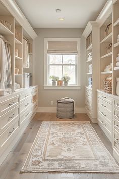 a large walk in closet with white cabinets and drawers