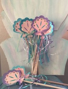 some paper flowers and sticks on a table