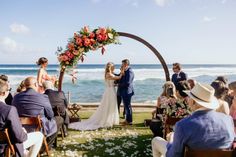 a bride and groom standing under an arch at the end of their wedding ceremony by the ocean