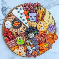 a wooden platter filled with lots of different types of halloween foods and candys