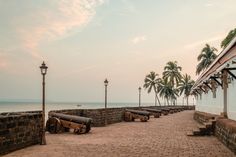 there are many logs lined up on the brick walkway by the water's edge