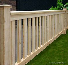 a close up of a wooden fence with grass in the background