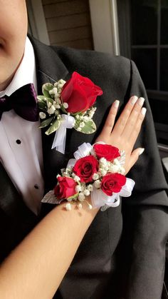 a man and woman in tuxedos with red roses on their lapel covers