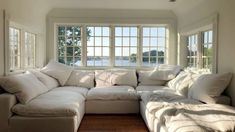 a large white couch sitting in front of two windows