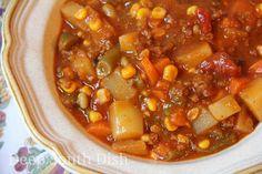 a bowl filled with chili and potatoes on top of a tablecloth covered table cloth