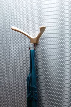 two toothbrushes are hanging on the wall next to a blue towel and an umbrella