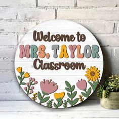 a wooden sign that says welcome to mrs taylor classroom with flowers and leaves on it