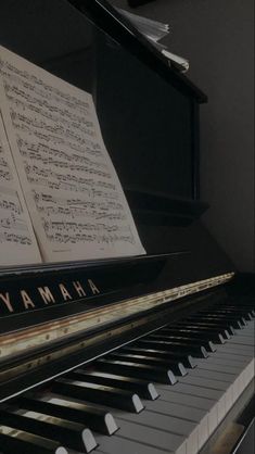 an old yamaha piano with sheet music on it's keys and the words yamaha written in black