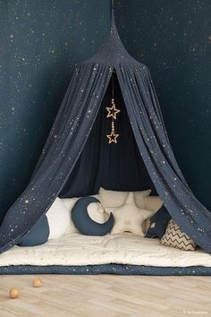 a child's bedroom with stars on the wall and a blue canopy over the bed