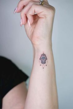 a woman's arm with a small tattoo on the left side of her wrist