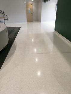 an empty room with white floors and green walls