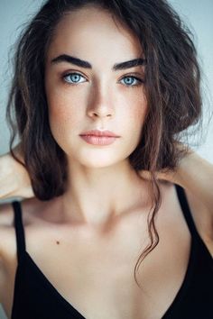 a beautiful young woman with blue eyes posing for the camera