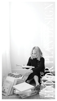 a woman is sitting on the floor with books in her hands and looking at them