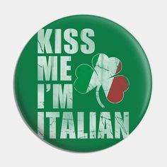 a green button with the words kiss me i'm italian and clovers on it