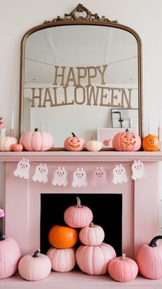 a pink fireplace decorated for halloween with pumpkins and ghost decorations