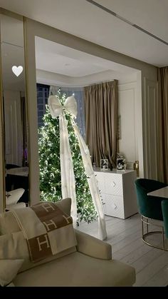 a living room filled with furniture and a christmas tree in the middle of the room