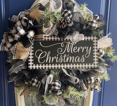 a christmas wreath with black and white plaid ribbon, pine cones and burlocks