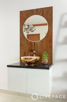 a bathroom with a sink, mirror and plant on the counter in front of it