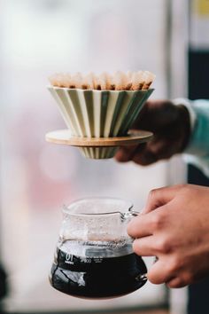 a person is holding a cup with some food in it