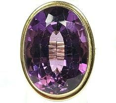 Vintage 19 Carat Oval Amethyst 14k Yellow Gold Ring. The ring has detailing all the way around the band.  The amethyst is massive with a deep purple color.  The ring is great condition with light wear including some small scratches on the top of the amethyst.  It weighs a heavy 10.6 grams. The top of the ring measures 26 by 19mm wide.  Pv780. Classic Oval Purple Amethyst Ring, Oval Purple Amethyst Ring For Formal Occasions, Deep Purple Color, Yellow Gold Ring, The Band, The Ring, Yellow Gold Rings, All The Way, Deep Purple