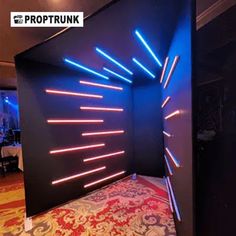 the room is decorated in black and blue with neon lights on the wall behind it