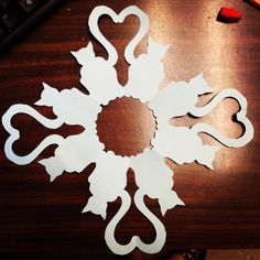 cut out paper flowers sitting on top of a wooden table next to a computer keyboard