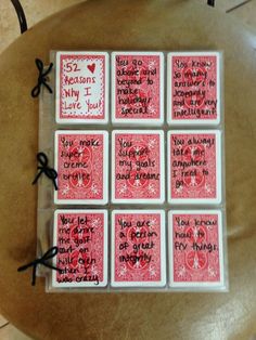 six red and white playing cards with words written on them sitting on a wooden table