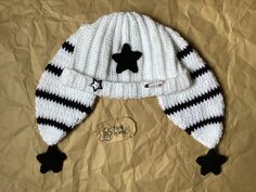 a white and black knitted hat with stars on the top, sitting on brown paper