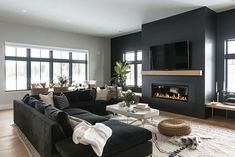 a living room filled with furniture and a flat screen tv mounted on the wall above a fire place