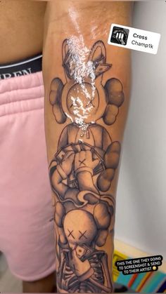 a person with a tattoo on their arm that has an image of mickey mouse and pluto