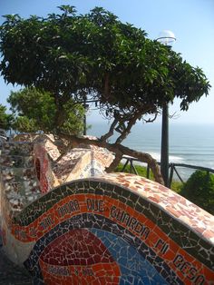 an artisticly designed bench next to the ocean