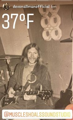 a man sitting in front of a guitar with the number 379f on it