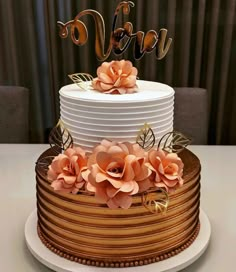 a three tiered cake with flowers and the word vera on top is sitting on a table