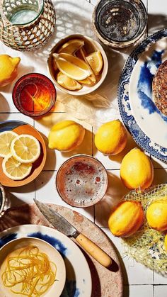 a table topped with plates filled with lemons and other dishes covered in different types of food