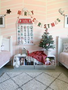 a room with two twin beds and a christmas tree in the corner on the wall