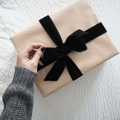 someone is holding a wrapped gift in their hand and it looks like they are going to give