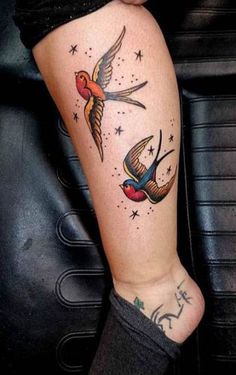 a woman's leg with two birds and stars on it