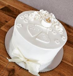 a white wedding cake on a wooden table