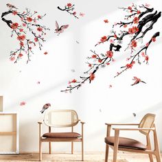 two chairs are in front of a wall with flowers and birds on it