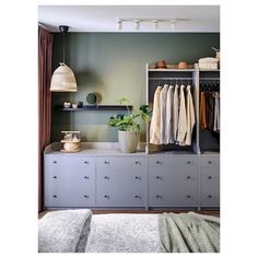 an open closet with clothes hanging on the shelves and other items sitting on top of it