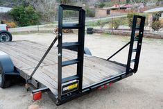 a flatbed trailer is parked in the dirt