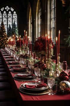 a long table set for christmas dinner with candles and decorations on the tables in front of it