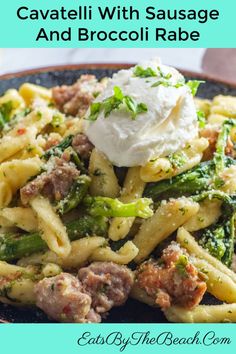 pasta with sausage and broccoli in a blue bowl on top of a table