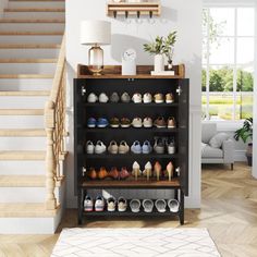 there are many pairs of shoes on the shelf next to the stairs in this living room