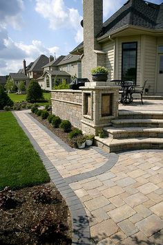 an outdoor patio with stone steps leading up to the front door and back yard area