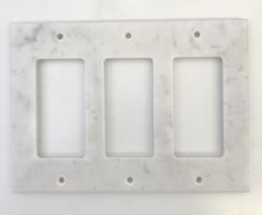 three white marble plates with holes in them