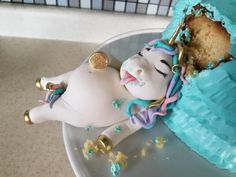 a cake shaped like a unicorn laying on its back