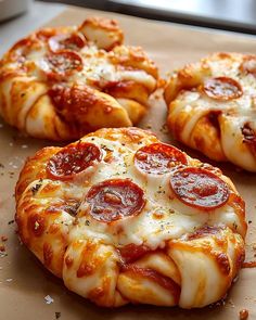 three pepperoni pizzas sitting on top of a cutting board